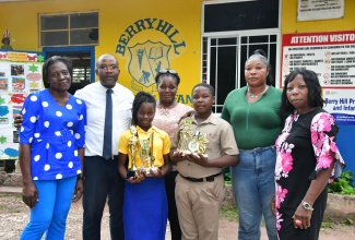 Top student at the Berry Hill Primary and Infant School in St. Catherine, Janea Harris (left, front row), and top boy, Teja Bailey (right, front row), celebrate their achievements recently at the school. Others (from left are) School Chair, Correl Davis; Principal, Duwayne Johnson; Janea’s grandmother, Charmaine Gordon; Teja’s mother, Yanique Harrison, and Senior Teacher, Velmore Lawson.