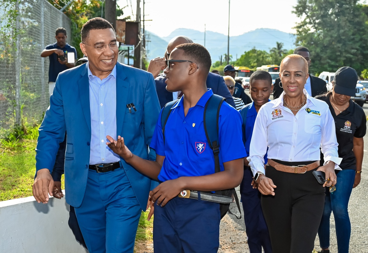 Prime Minister, the Most Hon. Andrew Holness, converses with a Jamaica College student while visiting the institution’s campus on Old Hope Road in St. Andrew, on Monday (September 2), the start of the 2024/25 academic year. Also visiting is Education and Youth Minister, Hon. Fayval Williams (right).
