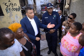 Prime Minister, Dr. the Most Hon. Andrew Holness (third left), speaks with fire victims during a visit to Bell Rock, St. Andrew on Tuesday (Sept. 17). He was accompanied by Commanding Officer for the St. Andrew South Division, Superintendent Damion Manderson. A deliberate fire destroyed seven homes, leaving 13 adults and nine children homeless.

