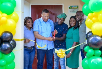 Prime Minister, Dr. the Most Hon. Andrew Holness (second left), and New Social Housing Programme beneficiary, Craig Bailey (third right), cut the ribbon to unveil Mr. Bailey’s new home in St. Catherine North Eastern, on September 19. Also pictured are ( from left) Permanent Secretary in the Ministry of Economic Growth and Job Creation, Arlene Williams; Member of Parliament for the constituency, Kerensia Morrison; and Councillor for the Guy’s Hill Division, Joseph Johnson.

