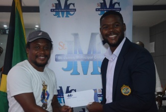 Mayor of Montego Bay and Chairman of the St James Municipal Corporation, Councillor Richard Vernon (right), hands over a Local Economic Development (LED) grant to local entrepreneur, Ricardo James, during the Grant Distribution Meeting at the Corporation’s Cambers, on September 18.

