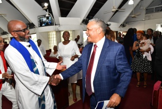 Airports Authority of Jamaica (AAJ) President and Chief Executive Officer, Audley Deidrick (right), is greeted by Pastor of Webster Memorial United Church in Kingston, Rev. Astor Carlyle, during the AAJ’s 50th anniversary commemorative service on Sunday (September 1).