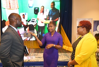 Minister of State in the Ministry of National Security, Hon. Juliet Cuthbert-Flynn (centre), is in discussion with Commissioner of Corrections, Brigadier (Ret.), Radgh Mason (left), and Chief Technical Director in the Ministry, Shauna Trowers, at the media launch of the DCS Correctional Management System (CMS), at the Jamaica Pegasus Hotel in New Kingston on Friday (Sept. 27).