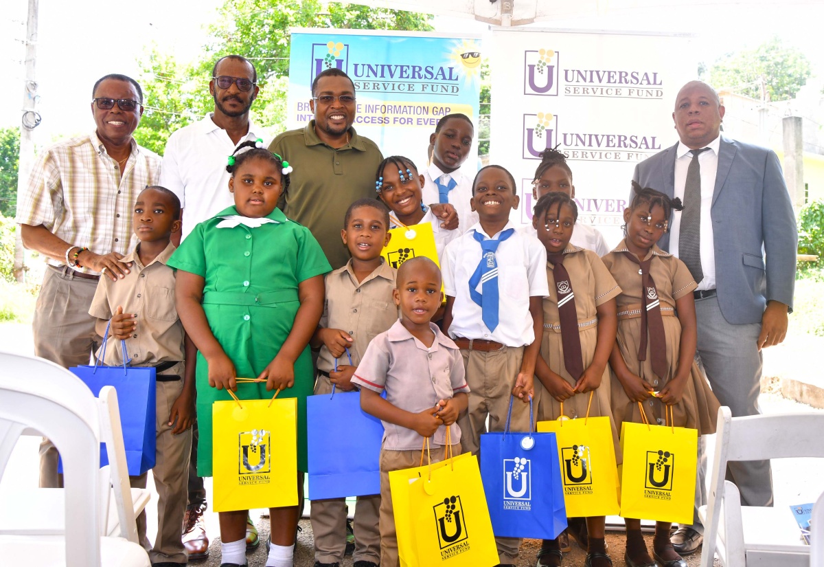 Member of Parliament for Clarendon North Central, Hon. Robert Morgan (third left, back row), along with (from left) Mayor of May Pen, Councillor Joel Williams; Councillor for the Chapelton Division, Hershell Brown, and Acting Chief Executive Officer of the Universal Service Fund (USF), Andrew McRae, with students who received tablet computers at yesterday’s (September 19), official installation of a free Wi-Fi hotspot in the community of Wood Hall.