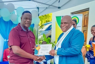 Parish Manager for the Social Development Commission (SDC) in Portland, Karl Coke (left), presents a Certificate of Recognition to Treasurer of the Buff Bay Development Area Committee (DAC), George Brown, at the staging of the inaugural Portland DAC Retreat held recently at Barhanna Vista Lodge in Port Antonio. The event, organised by the SDC through its Participatory Governance Programme, focused on community leadership and development.