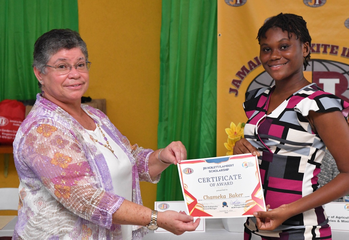 General Manager at the Jamaica Bauxite Institute (JBI), Yolanda Drakapoulos (left), presents a scholarship certificate to Chameka Baker, one of 14 tertiary-level scholars, who have benefitted under the JBI Hoilett/Lambert Scholarship. The presentation was made at the official launch of the scholarship at the JBI’s Hope Gardens location in St. Andrew on Friday (Sept. 13).