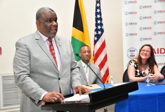 Permanent Secretary in the Ministry of Health and Wellness, Errol Greene, delivers an address on behalf of portfolio Minister, Dr. the Hon. Christopher Tufton, at the media launch of the One Health Project on Friday (Sept. 13) at the Jamaica Pegasus Hotel in New Kingston. Listening are Counsellor at the United States Agency for International Development (USAID), Clinton White, and Deputy Chief of Mission at the United States Embassy in Jamaica, Amy Tachco.