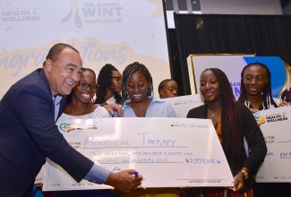 Minister of Health and Wellness, Dr. the Hon. Christopher Tufton (left), with some of the over 500 scholarship awardees at the recent ceremony, held at the AC Mariott Hotel, in New Kingston.

