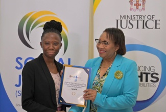 Ministry of Justice Officer, Shanielle Thompson (left), receives her certificate from Permanent Secretary, Grace Ann Stewart McFarlane, after completing a six-week Jamaican  Sign Language and Deaf Culture Training Course. The presentation was made during a graduation ceremony at Golf View Hotel in Mandeville, Manchester, on Thursday (September 12).
