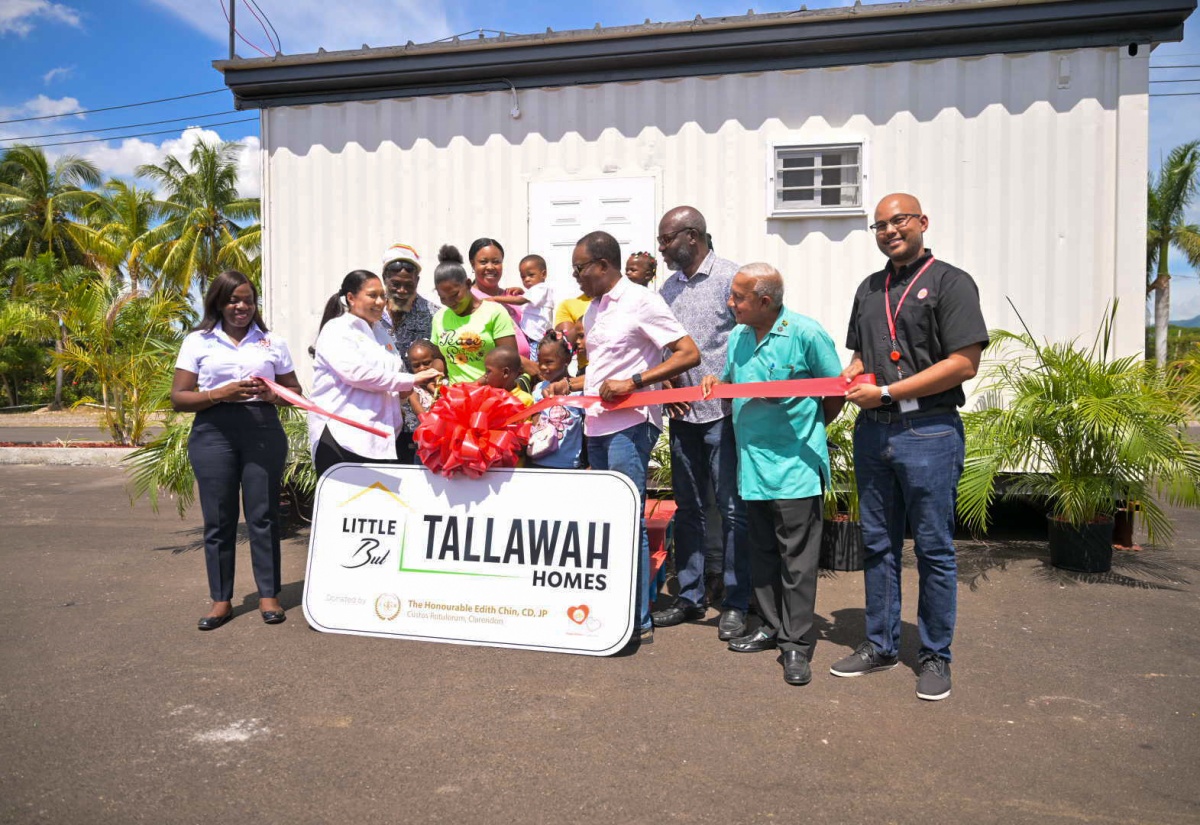 Custos Rotulorum for Clarendon, Hon. Edith Chin (second left), presents the keys to a new house (in background) built under her ‘Little But Tallawah Homes’ Initiative, to recipient, Tracy-Ann Thomas (fourth left) of Rocky Point in the parish, during the handover on Friday (September 20). Others participating include: Mayor of May Pen Councillor Joel Williams (third right), and Councillor for the Rocky Point Division, Winston Maragh (second right). 

