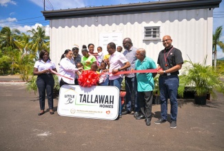 Custos Rotulorum for Clarendon, Hon. Edith Chin (second left), presents the keys to a new house (in background) built under her ‘Little But Tallawah Homes’ Initiative, to recipient, Tracy-Ann Thomas (fourth left) of Rocky Point in the parish, during the handover on Friday (September 20). Others participating include: Mayor of May Pen Councillor Joel Williams (third right), and Councillor for the Rocky Point Division, Winston Maragh (second right). 

