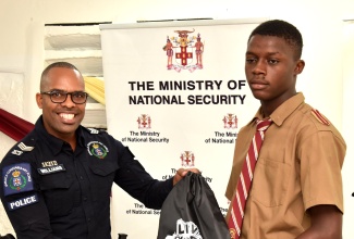 Sergeant Andrew Williams of the Jamaica Constabulary Force (JCF) Community Safety and Security Branch (CSSB), presents grade-11 student at Denham Town High School in Kingston, Kaydon Blair, with a ‘Liv Gud’ branded bag during an interactive session which members of the Ministry of National Security’s ‘Liv Gud’ team had with youngsters at the institution on Friday (September 20).