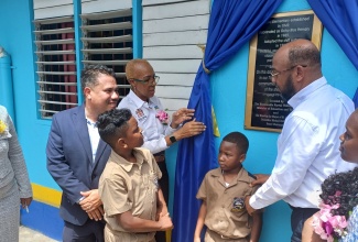 Minister of Education and Youth, Hon. Fayval Williams (second left), inspects a plaque on the wall on opening day of the 2024/2025 school year at the Ocho Rios Primary School in St. Ann on September 2. At left is Minister without Portfolio in the Ministry of Economic Growth and Job Creation, Senator the Hon Matthew Samuda, and at right is Mayor of St. Ann’s Bay, Councillor Michael Belnavis.   

