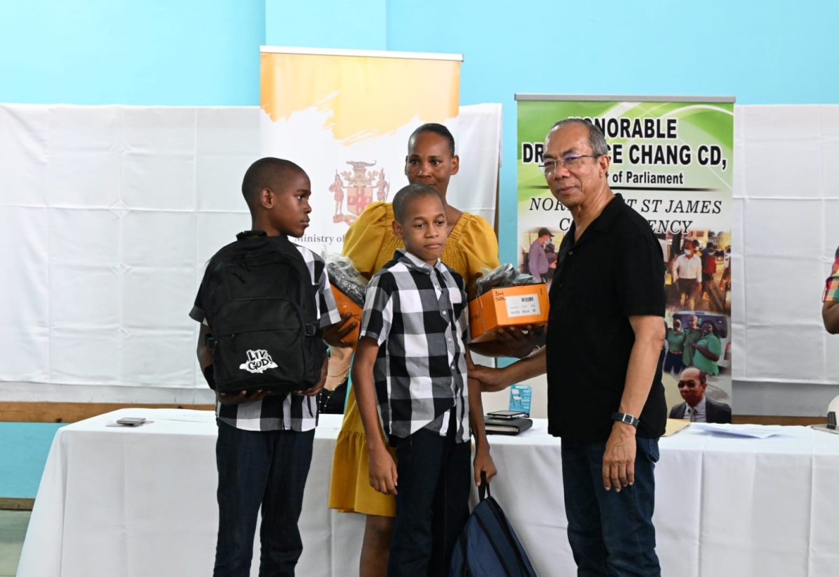 Deputy Prime Minister and Minister of National Security, Hon Dr. Horace Chang (right), participates in a recent handover of back-to-school supplies to students at the Flanker Community Centre in Montego Bay, St. James.