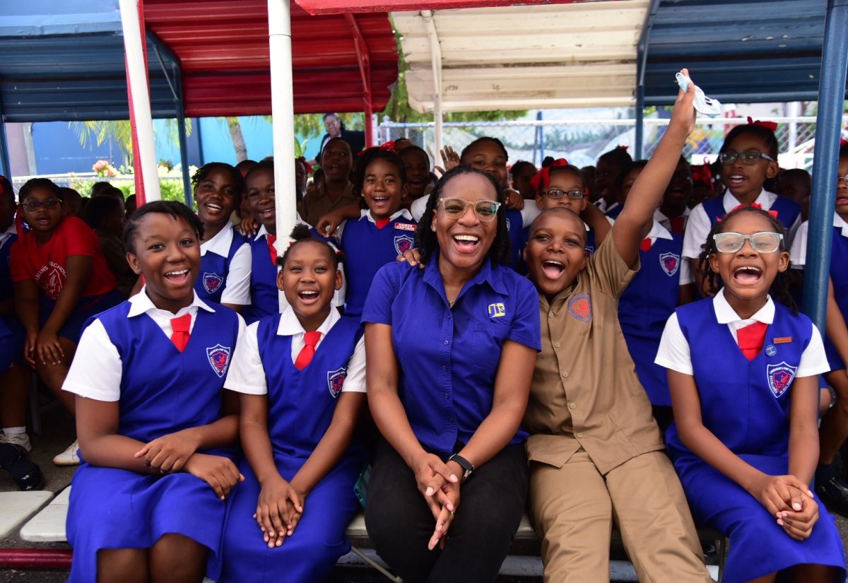 Acting Special Projects Manager at the Jamaica Information Service (JIS), Charnele Henry (seated, centre) shares a light moment with students from Lannaman’s Preparatory School (seated from left) Sabia Smellie, Tanice Barrett, Nosal Wilson, Malia DaCosta and other students, after the JIS Heritage School Tour visit to the institution on October 3. The students were engaged in an interactive discussion on the theme for Heritage Week ‘One Love, One People, One Heritage’.