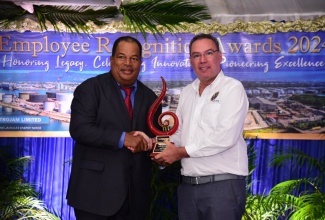 Minister of Science, Energy, Telecommunications and Transport, Hon. Daryl Vaz (right), presents Petrojam Limited employee, Mark Thomas, with an award for 40 years of distinguished service to the company, at an Employee Recognition Awards ceremony on Thursday (October 17), at the Terra Nova All-Suite Hotel in Kingston.