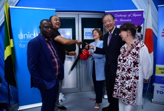 Minister of Health and Wellness, Dr. the Christopher Tufton (second left); United Nations Children’s Fund (UNICEF) Deputy Regional Director, Anne-Claire Dufay (centre) and Ambassador of Japan to Jamaica, His Excellency Yasuhiro Atsumi (second right), cut the ribbon to officially commission a cold room donated by the Government of Japan and UNICEF, at the National Health Fund’s (NHF’s) warehouse on Marcus Garvey Drive in Kingston on Thursday (October 24). Sharing the moment (from left) are NHF Chief Executive Officer, Everton Anderson; and UNICEF Representative, Jamaica Country Office, Olga Isaza.

