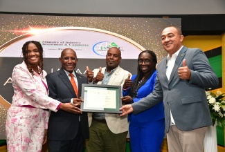 Minister of Industry, Investment and Commerce, Senator the Hon. Aubyn Hill (second left) and Chief Executive Officer of the Jamaica National Agency for Accreditation (JANAAC), Sharonmae Walker (left), present the ISO 15189:2012 certification for the Cornwall Regional Hospital (CRH) Laboratory to Minister of Health and Wellness, Dr. the Hon. Christopher Tufton (right) and Chief Executive Officer of CRH, Charmaine Williams-Beckford (second right). Sharing the moment is Deputy Mayor of Montego Bay, Councillor Dwight Crawford. The accreditation award ceremony was held at the Hilton Rose Hall Resort and Spa in St. James on October 17.