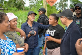 Minister of National Security, Hon. Dr. Horace Chang (right), and Member of Parliament for Central Manchester, Rhoda Moy Crawford (3rd left), meet with residents of Albion in Manchester, during a tour of communities in the parish on Thursday (Oct. 17).