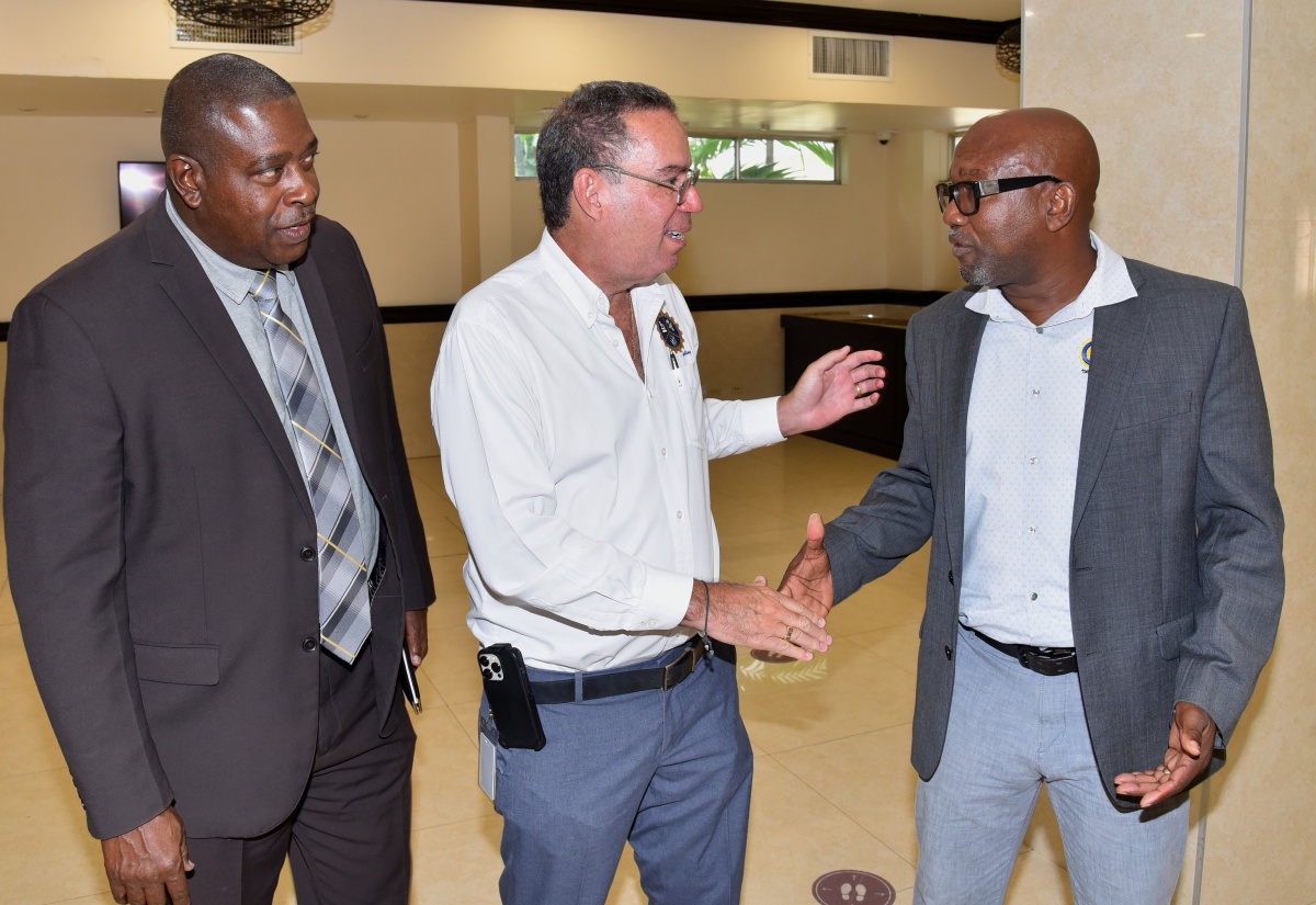 Minister of Science, Energy, Telecommunications and Transport, Hon. Daryl Vaz (centre), greets Director of Grennel Driving School, Alphanso Grennell (right), during the staging of the Crash No More 2024 Defensive Driving Workshop, held at The Jamaica Pegasus hotel in New Kingston, on October 2. Observing (at left) is Head of the Jamaica Constabulary Force (JCF) Public Safety and Traffic Enforcement Branch (PSTEB), Assistant Commissioner of Police (ACP) Gary McKenzie.