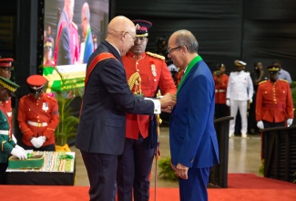 Governor-General, His Excellency the Most Hon. Sir Patrick Allen (left), presents the Order of Jamaica (OJ) to Deputy Prime Minister and Minister of National Security, Hon. Dr. Horace Chang, at the National Honours and Awards Ceremony held on Monday (Oct. 21), at the National Indoor Sports Centre in Kingston.