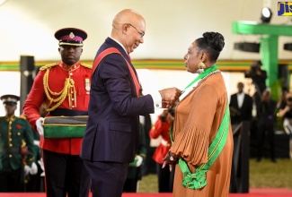 Governor-General, His Excellency The Most Hon. Sir Patrick Allen, presents Minister of Culture, Gender, Entertainment and Sport, Hon. Olivia Grange, with the Order of Jamaica (OJ), during the Ceremony of Investiture and Presentation of National Honours and Awards held at King’s House on October 17, 2022.

