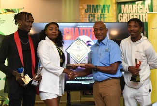 Executive Director of the Jamaica Cultural Development Commission (JCDC), Lenford Salmon (second right), presents the winning trophy in the JCDC FiWi Short Film Competition to Sabrina Thomas (second left) for her drama ‘Shattered’, at the recent awards ceremony held at The Roof Terrace of the Ministry of Culture, Gender, Entertainment and Sport in New Kingston. Sharing the moment are Daneilo Reid (left), the film’s editor, and cameraman Corneilous Grand. ‘Shattered’ also won awards for Best Editing, Best Directing, Best Drama, and Best Film (Adult category). The film’s lead actress Shashana Lamot also won in the Best Actress category.

