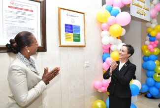 Minister of Foreign Affairs and Foreign Trade, Senator the Hon. Kamina Johnson Smith and Permanent Secretary in the Ministry, Ambassador Sheila Sealy Monteith, applaud after unveiling the Ministry’s first Citizen’s Charter, during a ceremony at the Ministry, Port Royal Street, in downtown Kingston, on October 10.

