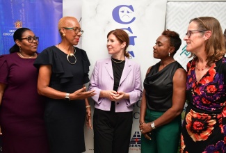 Minister of Education and Youth, Hon. Fayval Williams (second left), and Minister of State in the Ministry of National Security, Hon. Juliet Cuthbert-Flynn (second right), engage with stakeholders during Tuesday’s (October 15) launch of the six-year United Kingdom (UK)-Jamaica Violence Prevention Partnership Programme, at Edward Seaga Primary School in Kingston. Listening are British High Commissioner to Jamaica, Her Excellency Judith Slater (right); Parliamentary Under-Secretary of State for Latin America and the Caribbean in the UK Foreign Commonwealth and Development Office, Baroness Jennifer Chapman of Darlington (centre), and the school’s Principal, Shernet Clarke-Tomlinson.
