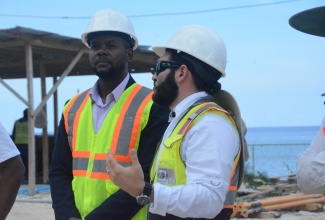 Mayor of Montego Bay, Councillor Richard Vernon (left), listens to Project Manager, RCD Hotels, Albert Varez, during a visit to the construction site of the Hard Rock Hotel & Casino along the Rose Hall main road, during an infrastructure tour of St. James on Tuesday (October 9).

