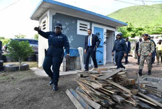 Prime Minister, Dr. the Most Hon. Andrew Holness (second left), and members of the security forces are led by Superintendent of Police in charge of the Kingston Eastern Division, Tomielee Chambers (left), in the community of Pleasant Heights, Rockfort, in Kingston, on Tuesday (October 22). There was a mass shooting at a football match in the community on National Heroes Day (October 21), which resulted in the death of five persons. 

