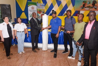 Minister of State in the Ministry of Agriculture, Fisheries and Mining, Hon. Franklyn Witter (third left), presents a group of greenhouse farmers with inputs for their business, to replace what was lost during the passage of Hurricane Beryl. Occasion was a World Food Day Ceremony, held at Ebony Park in Clarendon, on October 16. 
