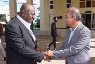 Minister of National Security, Hon. Dr. Horace Chang (right), is greeted by Acting Deputy Commissioner of Police, Andrew Lewis, at the National Police College of Jamaica in St. Catherine, on October 8, where the Jamaica Constabulary Force (JCF) hosted a mental health symposium.

