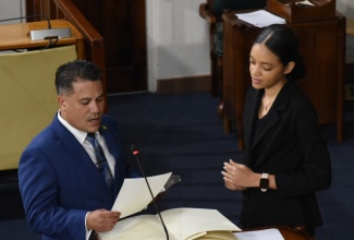 New Member of Parliament for St. Ann North East, Matthew Samuda, takes the Oath of Allegiance during the sitting of the House of Representatives on October 8. At right is Acting Clerk to the Houses of Parliament, Chesanne Brandon.

