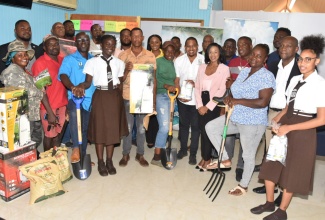 Minister of Agriculture, Fisheries and Mining, Hon. Floyd Green (seventh right), shares a moment with Clarendon farmers who have benefited from a donation of supplies from Jamaica Bauxite Mining Limited (JBML). Occasion was the handover of the items at the Rural Agricultural Development Authority (RADA) parish office in Clarendon on Tuesday (October 29). He is joined by Principal Director of Technical Services at RADA, Winston Simpson (third left); and Managing Director of JBML, Donna Howe (sixth right).

