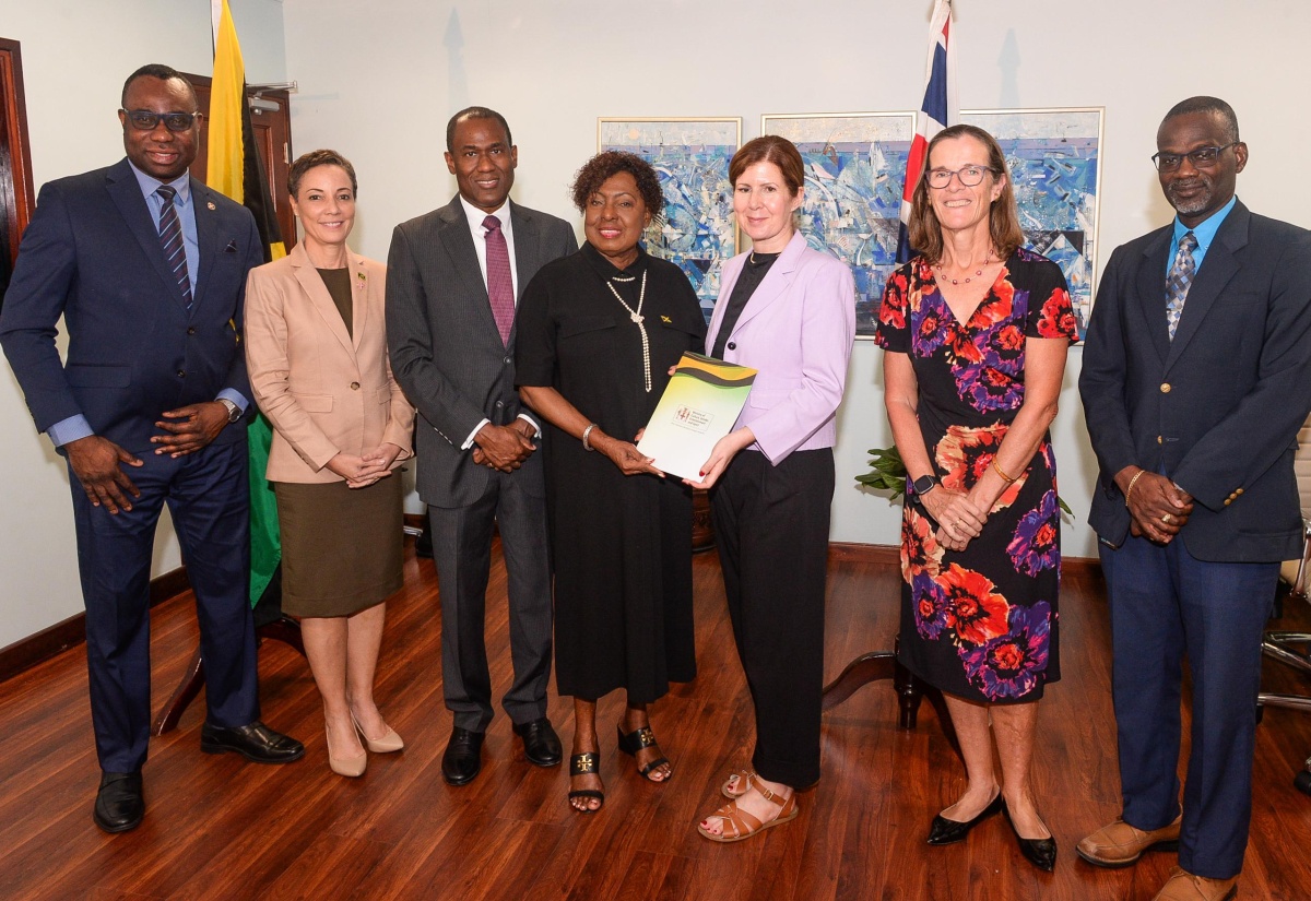 Minister of Culture, Gender, Entertainment and Sport, Hon. Olivia Grange (centre), and United Kingdom (UK) Minister for Latin America and the Caribbean, Baroness Jennifer Chapman (third right), display a signed agreement for a feasibility study for the National Stadium Redevelopment Project. Occasion was a press conference at the Culture Ministry in New Kingston on Tuesday (October 15) to provide an update on the project. They are joined by (from left) Supernumerary Permanent Secretary in the Culture Ministry, Dean-Roy Bernard; Minister of Foreign Affairs and Foreign Trade, Senator the Hon. Kamina Johnson Smith; Minister of Finance and the Public Service, Dr. the Hon.  Nigel Clarke; British High Commissioner to Jamaica, Judith Slater; and Permanent Secretary in the Ministry of Culture, Gender, Entertainment and Sport, Denzil Thorpe.

