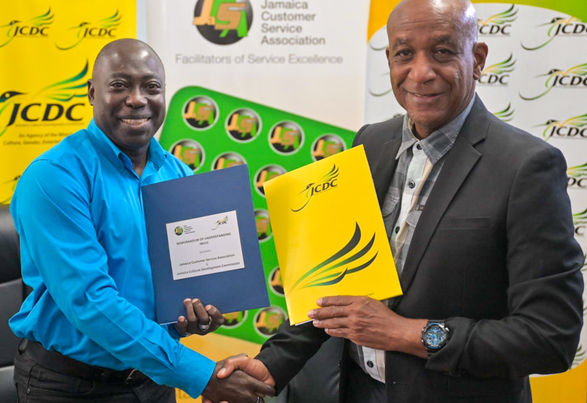 Deputy Chairman, Jamaica Customer Service Association (JaCSA) and Chair, National Customer Service Week (NCSW), Richard Rowe (left), and Executive Director, Jamaica Cultural Development Commission (JCDC), Lenford Salmon, shake hands following the signing of a Memorandum of Understanding (MOU) to formalise the entities’ partnership in coordinating the annual Jamaica Customer Service Poetry Competition. The MOU was signed during a brief ceremony at the JCDC’s head office in Kingston on Friday (October 11).