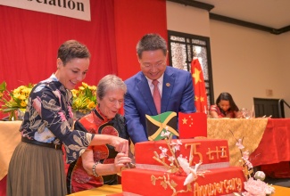 Minister of Foreign Affairs and Foreign Trade, Senator the Hon. Kamina Johnson Smith (left), joins Chinese Ambassador to Jamaica, His Excellency Chen Daojiang (right) and President of the Jamaica China Friendship Association, Irena Cousins, in a cutting a cake to celebrate the 75th anniversary of the founding of the People’s Republic of China, during the Association’s annual banquet held at The Jamaica Pegasus hotel in New Kingston on Sunday (October 13).

