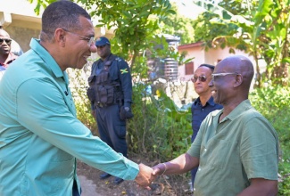 Prime Minister, Dr. the Most Hon. Andrew Holness (left), greets Minister of Local Government and Community Development, Hon. Desmond McKenzie, during the handover of an Indigent Housing unit in Seaforth, St. Thomas, on October 25.

