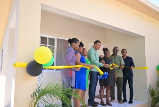 Prime Minister, Dr. the Most Hon. Andrew Holness (centre), leads a ribbon-cutting exercise for an Indigent Housing solution in Seaforth, St. Thomas, on October 25. Sharing the moment are Minister of Local Government and Community Development, Hon. Desmond McKenzie (second right) and (from left) Permanent Secretary in the Ministry of Local Government and Community Development, Marsha Henry-Martin; Councillor for the Seaforth Division, Sheroo Stephens; daughter of the beneficiary, Vijae Bartley; beneficiary, Marsha Davis; and Mayor of Morant Bay, Councillor Louis Chin.