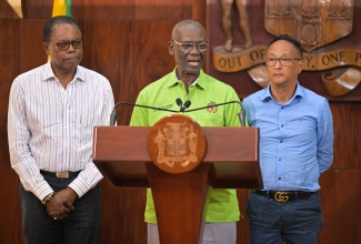 Minister of Local Government and Community Development, Hon. Desmond McKenzie (centre), speaks at today’s (October 30) post-Cabinet press briefing at Jamaica House. The Minister is accompanied by Mayor of May Pen, Councillor Joel Williams (left), and Mayor of Morant Bay, Councillor Louis Chin.

