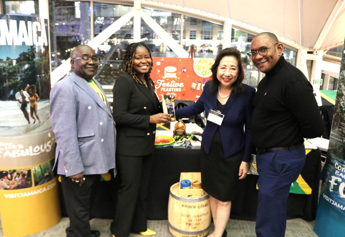 Minister-Counsellor for Trade at the Embassy of Jamaica in Washington DC, Alicia Taylor, presents Jamaican Blue Mountain Coffee to Secretary of the State of Maryland, Susan C. Lee, who stopped at Jamaica’s booth at Maryland’s State of the Ports and Global Flavor Showcase held recently in Baltimore.  Sharing the moment (from left) are: Travel Consultant, Chris Davis and Security Attaché at the Embassy, Ewon Simms.