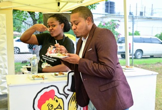 Minister of Agriculture, Fisheries and Mining, Hon. Floyd Green (right) samples a dish prepared by Kibbieshe Kennedy, a contestant in the Ministry’s Eat Jamaican Month Cook Off competition, held on Friday (November 29) at the Ministry’s Hope Complex in Kingston.