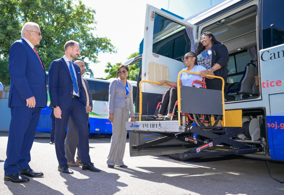 Minister of Justice, Hon. Delroy Chuck (left), accompanied by (from second left) United Nations Development Programme (UNDP) Goodwill Ambassador, His Royal Highness, Crown Prince Haakon of Norway; UNDP Resident Representative, Kishan Khoday, and Executive Director, Legal Aid Council, Dian Watson, observe as Therese Braham, who uses a wheelchair, is lifted into a Mobile Justice Unit. She is aided by Legal Officer, Nyoka Graydon-Johnson. The occasion was a tour of the unit at the Ministry’s Head Office in Kingston on Tuesday (November 19).

