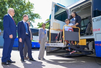 Minister of Justice, Hon. Delroy Chuck (left), accompanied by (from second left) United Nations Development Programme (UNDP) Goodwill Ambassador, His Royal Highness, Crown Prince Haakon of Norway; UNDP Resident Representative, Kishan Khoday, and Executive Director, Legal Aid Council, Dian Watson, observe as Therese Braham, who uses a wheelchair, is lifted into a Mobile Justice Unit. She is aided by Legal Officer, Nyoka Graydon-Johnson. The occasion was a tour of the unit at the Ministry’s Head Office in Kingston on Tuesday (November 19).

