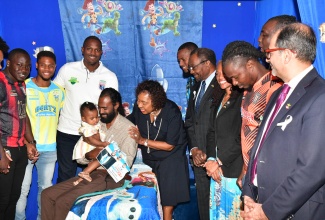 Minister of Culture, Gender, Entertainment and Sport, Hon. Olivia Grange (fifth left), interacts with Filippe Folkes and his daughter, Janani, as other stakeholders look on, during the unveiling of the Daddy Day Care Series during Tuesday’s (November 19) International Men’s Day Forum at the Jamaica Pegasus Hotel in New Kingston. A wide cross section of men and boys attended the event, observed under the international theme: ‘Men’s Health Champions’, and the local theme: ‘Aspire to Inspire: Healthy Men, Healthy Families’. The Daddy Day Care Series is being undertaken in partnership with the Women’s Centre of Jamaica Foundation and Professional Football Jamaica Limited.

