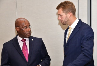 Minister of Industry, Investment and Commerce, Senator the Hon. Aubyn Hill (left), converses with Vice President, HDF Energy Caribbean, Thibault Ménage, during the Caribbean Competitiveness: Global Partnership for Infrastructure Development meeting, hosted by the Caribbean Council Initiative, at the AC Hotel by Marriott Kingston on Thursday (October 31).