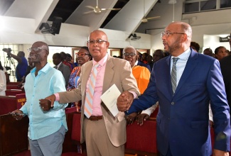 Minister of Local Government and Community Development, Hon. Desmond McKenzie (left); Spanish Town Mayor, Councillor Norman Scott (centre), and Mayor of St. Ann’s Bay, Councillor Michael Belnavis, hold hands while participating in Sunday’s (November 3) Local Government Month church service at Webster Memorial United Church in St. Andrew. 

