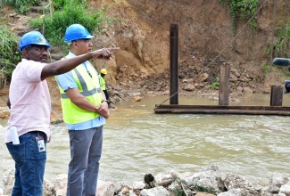 Prime Minister, Dr. the Most Hon. Andrew Holness (right) is joined by Senior Director at the National Works Agency (NWA), Varden Downer, during a tour of the work being undertaken to rebuild the Troy Bridge in Trelawny on November 8.