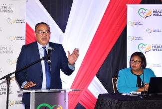 Minister of Health and Wellness, Dr. the Hon. Christopher Tufton, addresses the press launch of the 2023 National Drug Prevalence Survey at the Terra Nova All-Suite Hotel in St. Andrew on Monday (November 11). Listening is Senior Director at the National Council on Drug Abuse (NCDA), Uki Atkinson.

